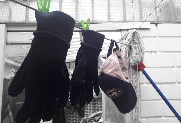 Guantes, gorra y trapero, secando tras haber sido lavados para evitar la transmisi&oacute;n del virus