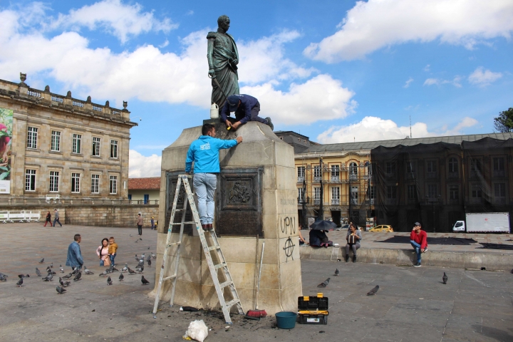 Miembros de la Alcaldía tratando de limpiar el monumento a Simón Bolívar.