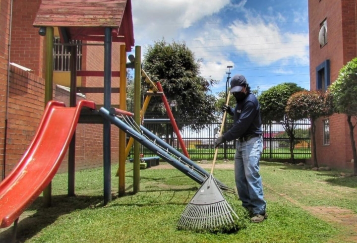 Un trabajador mantiene sus funciones habituales de aseo y mantenimiento al interior del conjunto residencial Portal de San &Aacute;ngel.
