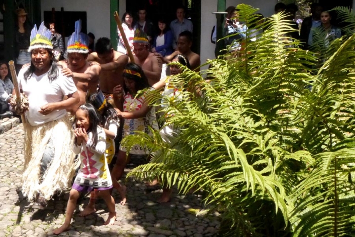 Un ni&ntilde;a Uitoto sonrie al danzar y cantar junto a los mienbros de su comunidad.