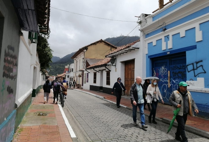 Turistas recorriendo el barrio La Candelaria en Bogotá en compañía de un guía.  Foto de Paola Montañez