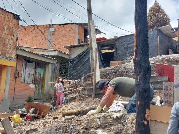 Hombre y niña trabajan en la reconstrucción de su hogar