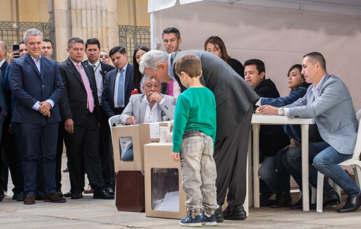 El expresidente y senador Álvaro Uribe Vélez votando en compañía de su nieto. Foto: Julián Ríos