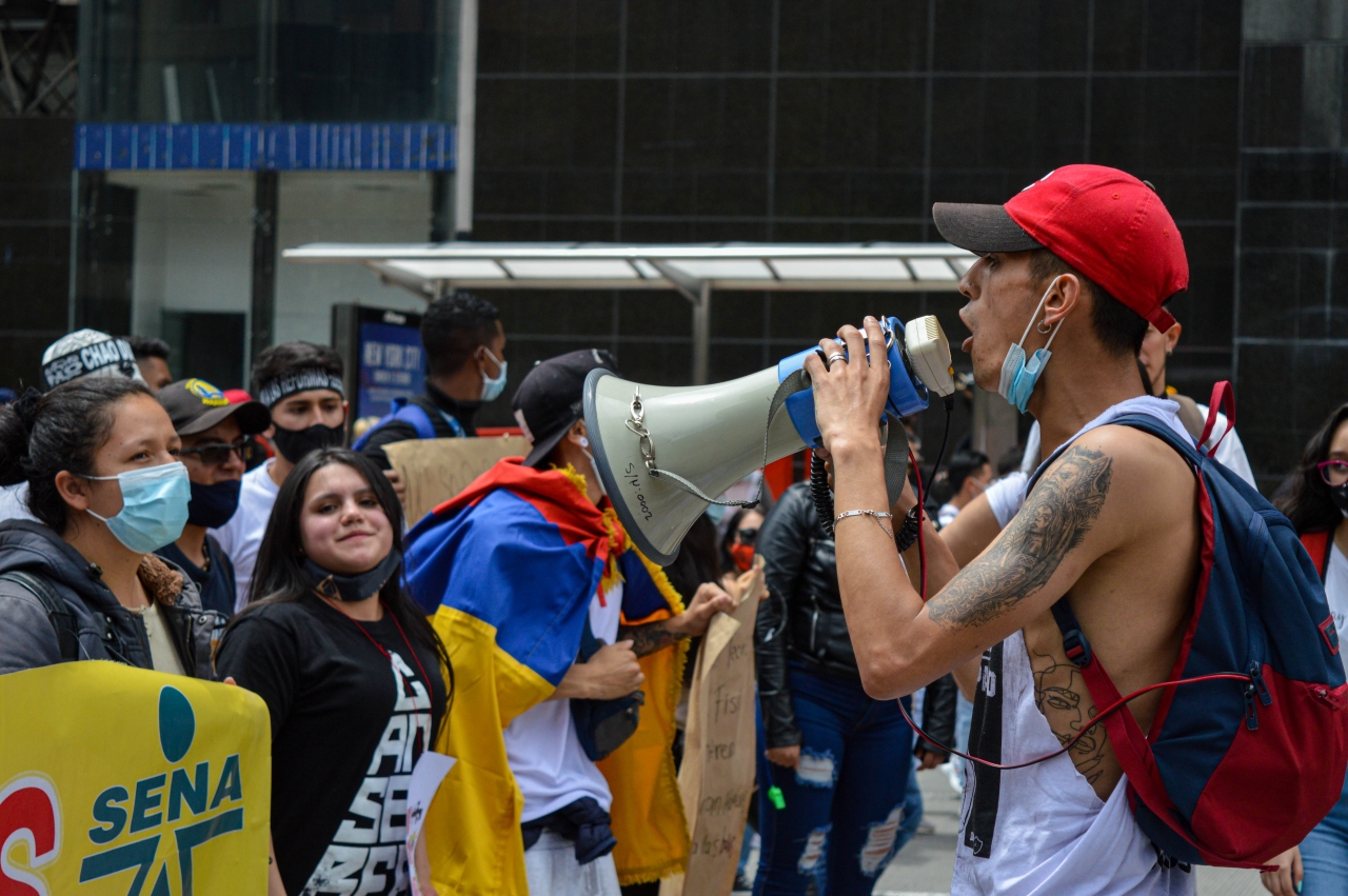 Manifestante cantando arengas|Manifestación U.Nacional|Banderas en la manifestación|Multitudinaria marcha hacia el norte de Bogotá|||