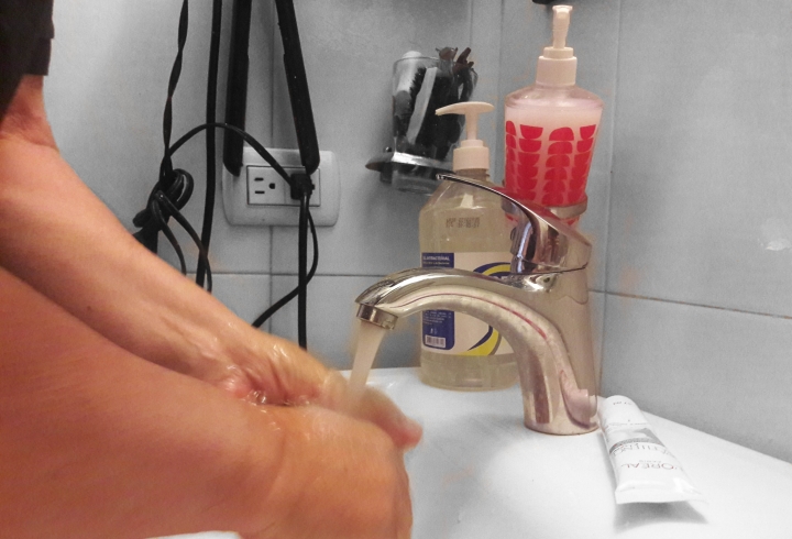 Padre de familia lavándose las manos en el baño de su hogar