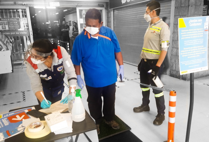 Punto de desinfección de manos y pies en la entrada a Homcenter, en este se rocían a los clientes con alcohol como medida preventiva