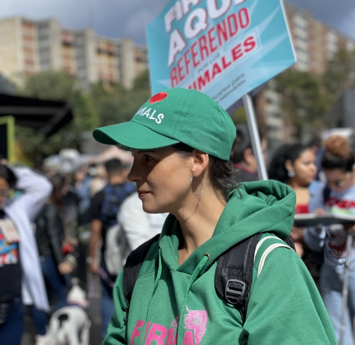 Andrea recolectando firmas para el Referendo por los Animales. Su gorra dice: “I Love Animales”.