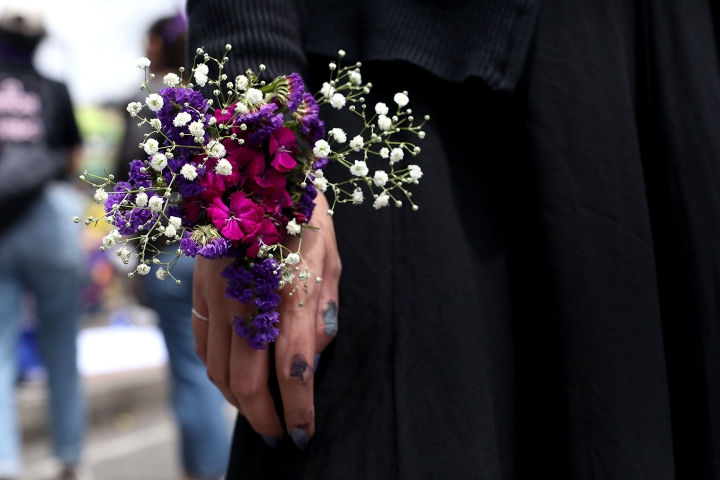 Manifestante con flor en la mano