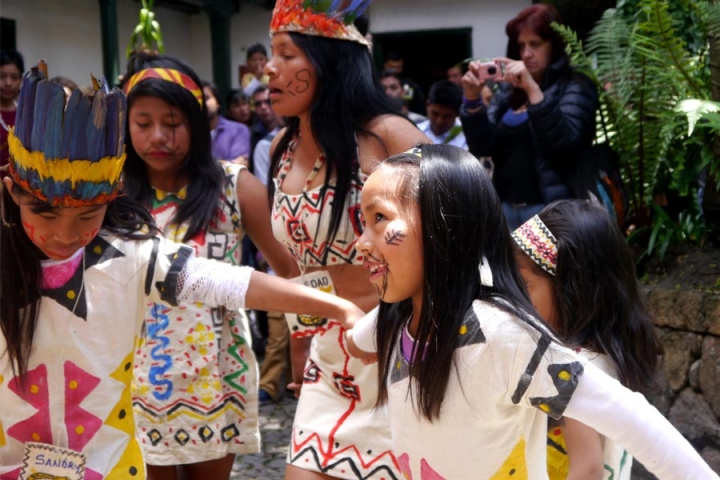 Una de las mujeres del grupo se desplaza danzando al centro del grupo para indicarle a los niños como deben danzar.