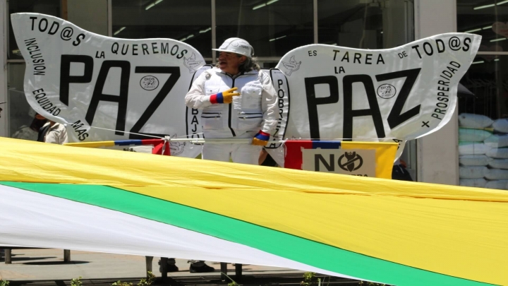 Una de las representaciones simbólicas de la paz en la carrera Séptima y debajo la bandera de la Unión Patriótica.