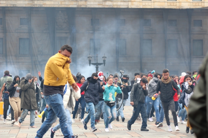 Jóvenes huyen de gases lacrimógenos en la Plaza Simón Bolívar el 22N