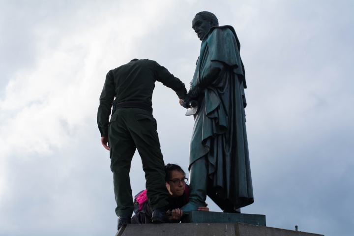 Aferrada al pie de la estatua desvestida, la mujer que intentó convertir a Simón en &quot;Simona&quot; hace resistencia. Foto: Julián Ríos