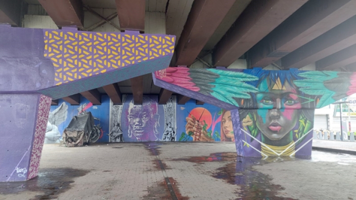 Intervenci&oacute;n art&iacute;stica en el puente Avenida Ciudad de Quito con Av. Gabriel Andrade (Calle 68). Al fondo, en el lado izquierdo yace un cambuche.