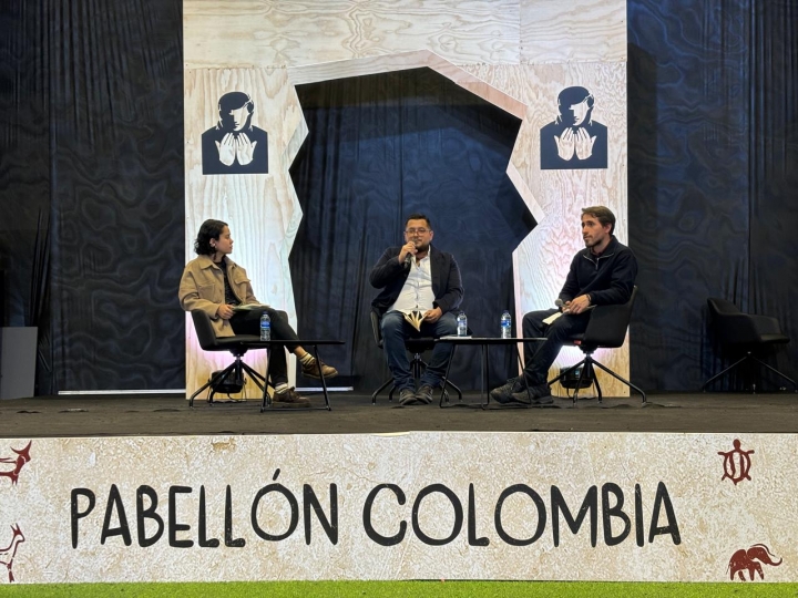 Ligia Trujillo, Jorge Carreño y Manuel Valdivieso sentados en la lectura de poemas en el pabellón Colombia.