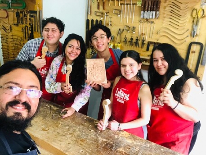 Luis Felipe en el medio con su maestro y compañeros en el taller.