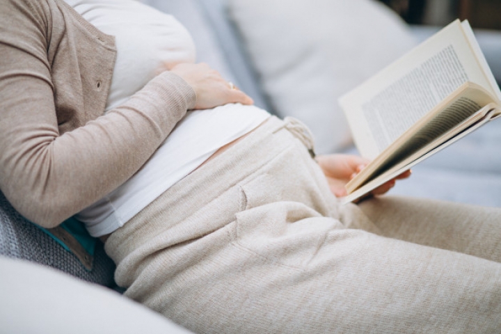 Mujer embarazada leyendo